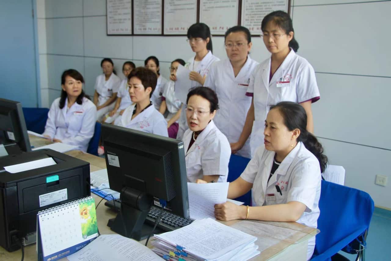 Traditional Chinese Medicine expert Dr Qin Xu with students and researchers in China