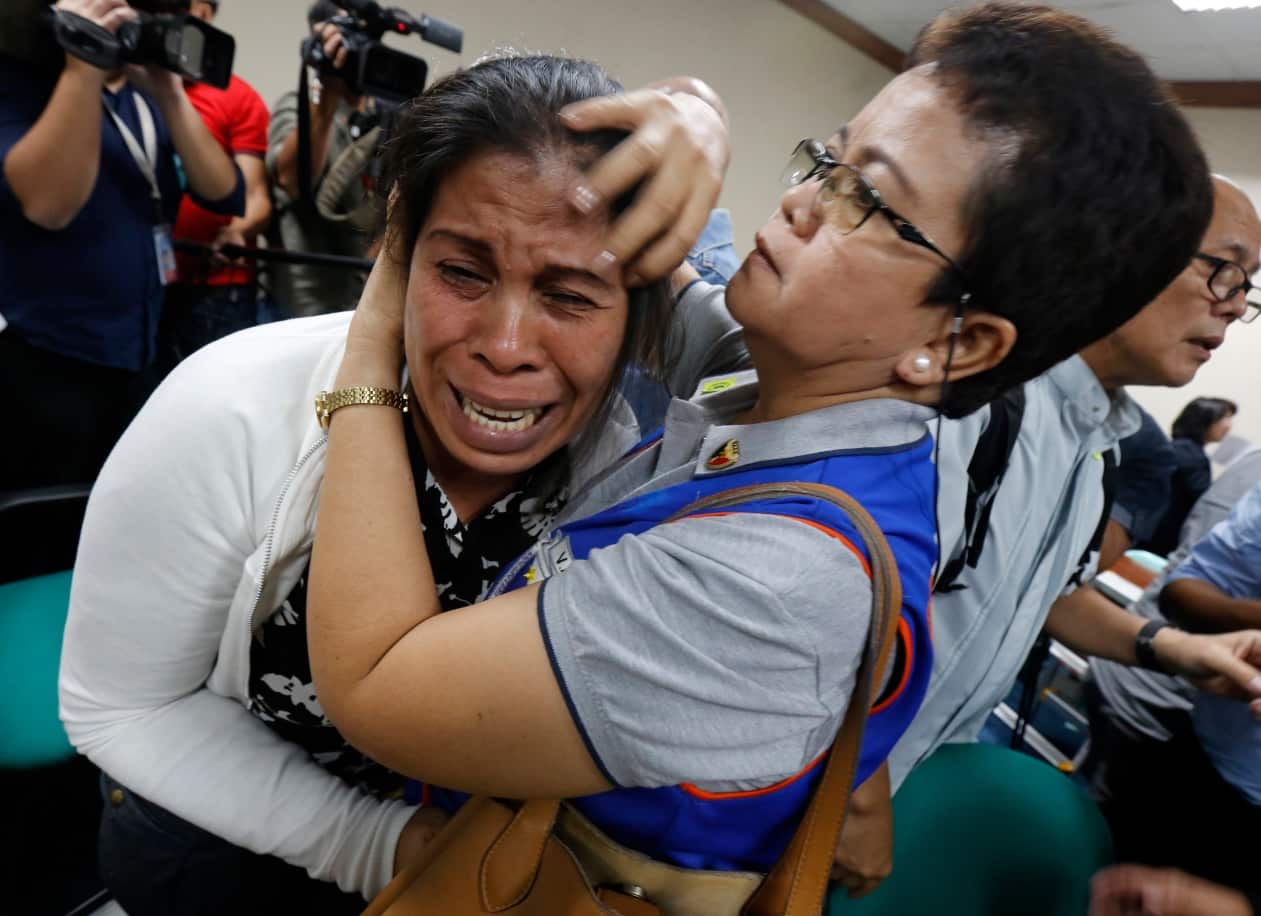 Filipino Lorenza Delos Santos (L), mother of student Kian delos Santos, breaks out in tears as she is comforted by a symphatiser during the trial.
