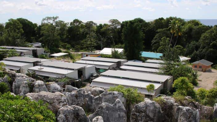 A cluster of corrugated iron huts resembling military barracks jut out of Nauru's sweltering rocky landscape to reveal refugee settlement camp number five.