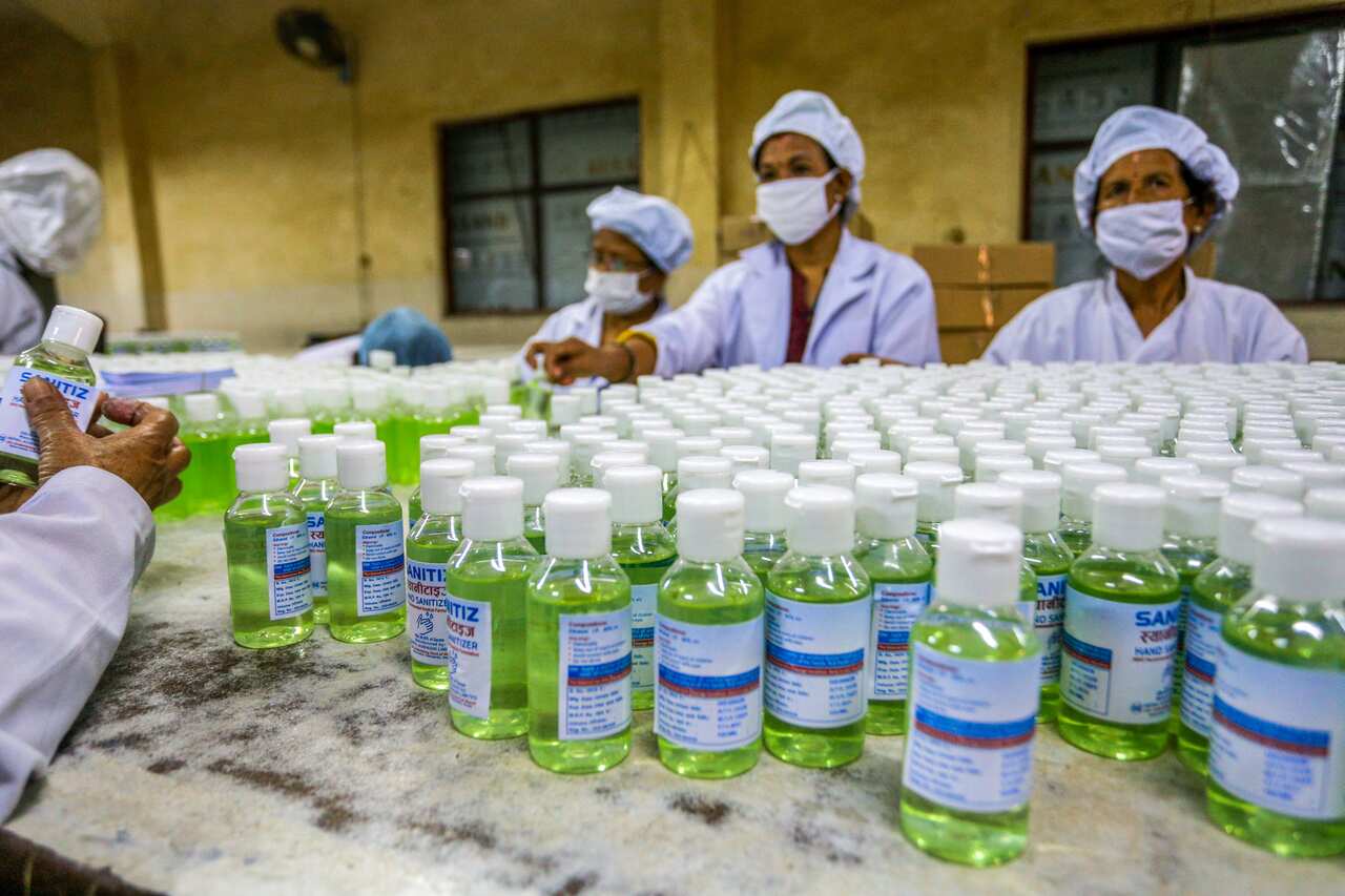 Workers label bottles of hand sanitizer at Nepal Aushadhi Limited during the twentieth day of nationwide lockdown.