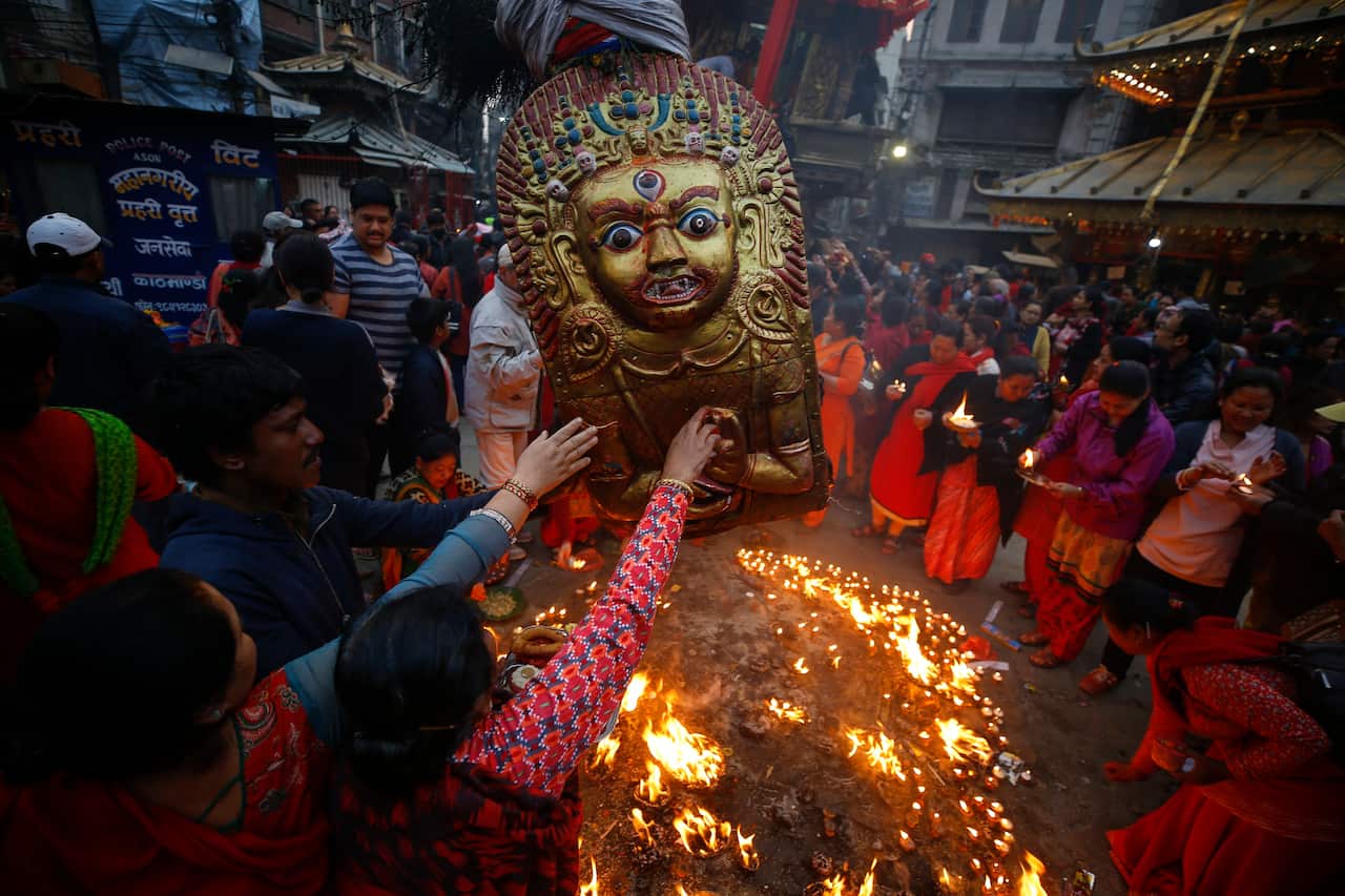 Nepalese devotees offer prayers to a 28-foot-high (8.5 metre) giant chariot of Seto (white) Machindranath, the god of protection, in an early morning in Kathmandu, Nepal, 26 March 2018.