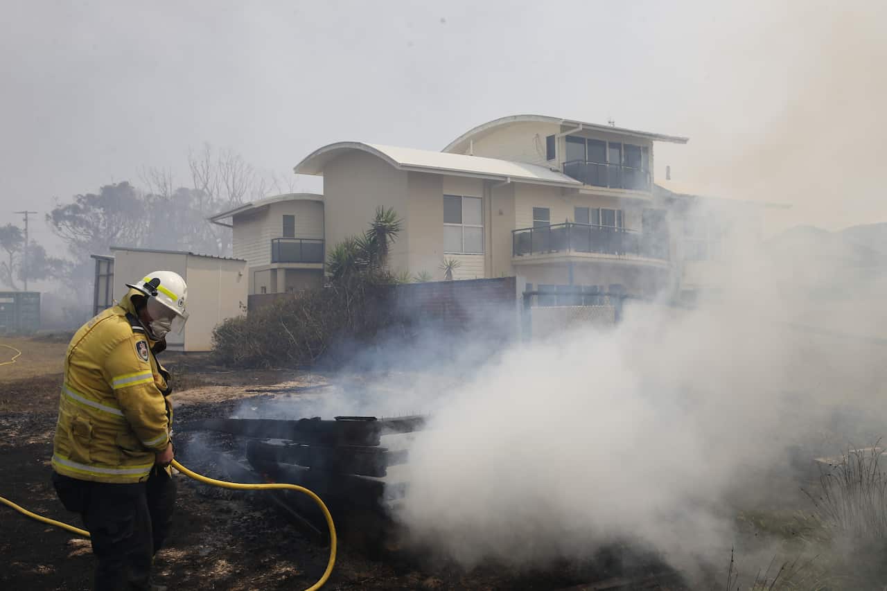 Firefighters work to contain a bushfire along Old Bar road in Old Bar, NSW, Saturday, November 9, 2019. 
