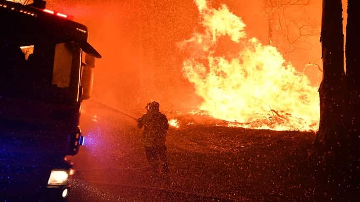 NSW Fire and Rescue officers battle a bushfire near Termeil on the Princes Highway between Batemans Bay and Ulladulla 3 December, 2019