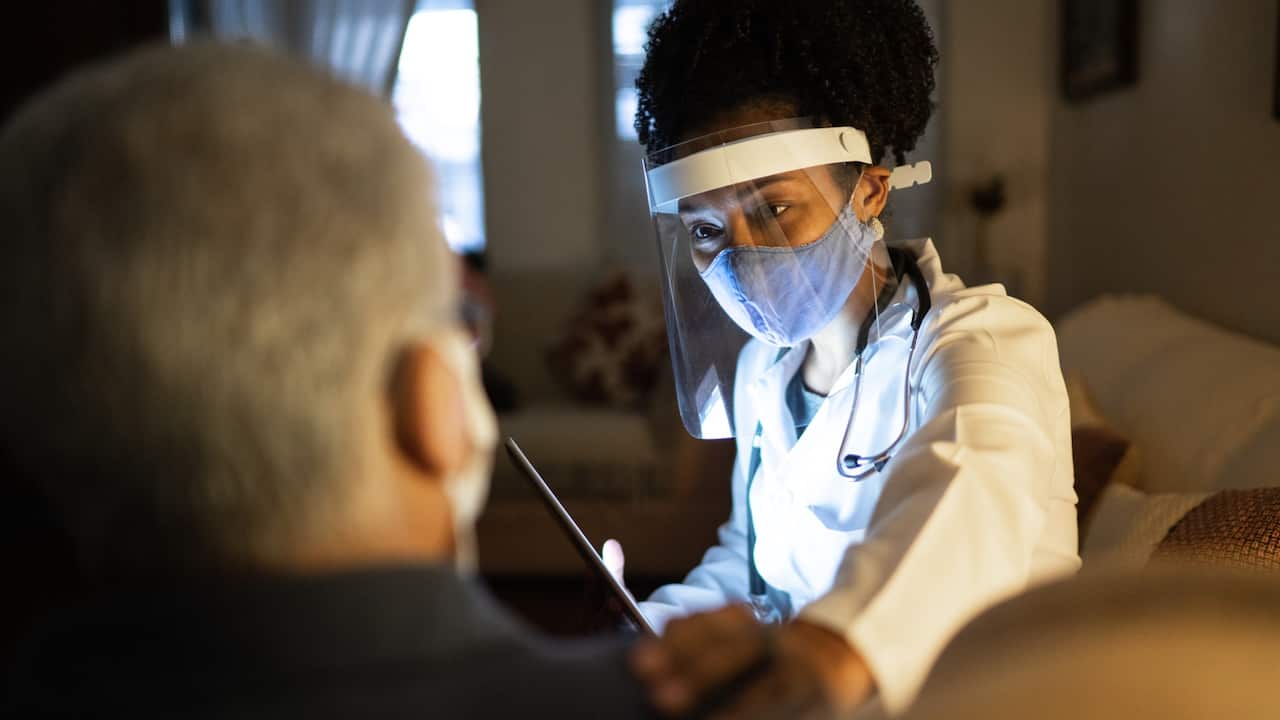 Nurse examining a patient Man looking out the window 