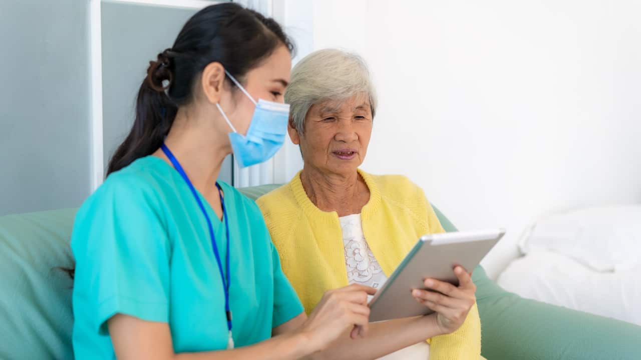 Nursing helping patient with tablet
