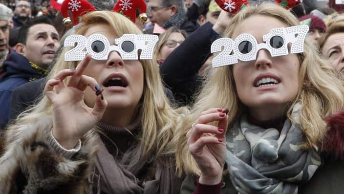 People gather to eat grapes in time to the midday strokes in Plaza del Sol square, Madrid.