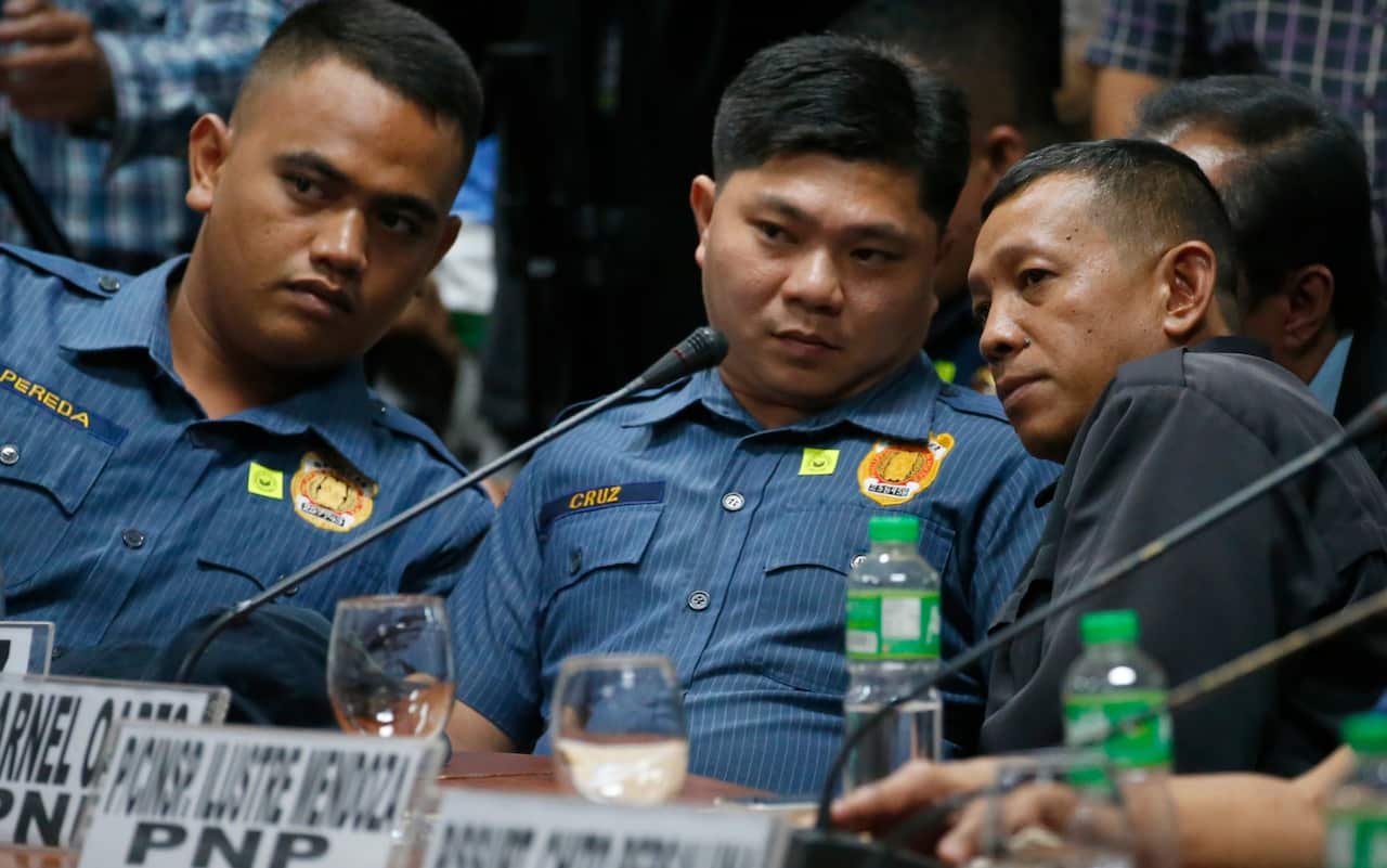 File photo, from left; police officers Jeremias Pereda, Jerwin Cruz and Arnel Oares talk during a senate hearing on the killing of Kian.