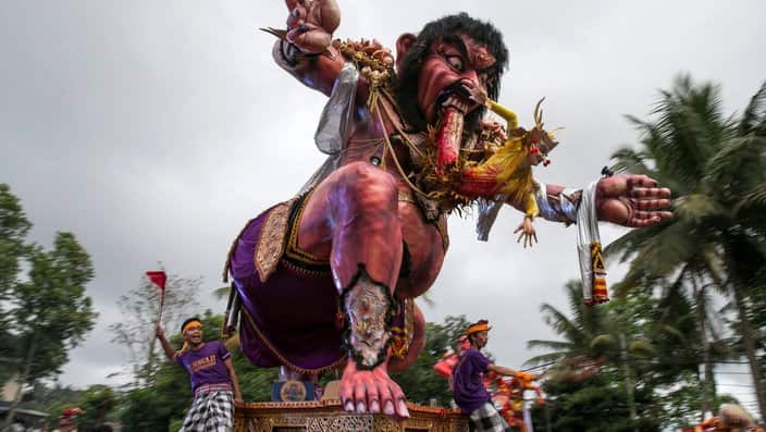 Balinese carry giant effigies in the form of the devil, whose local name is 'Ogoh-ogoh', during a parade before Nyepi Day, the Balinese Day of Silence.