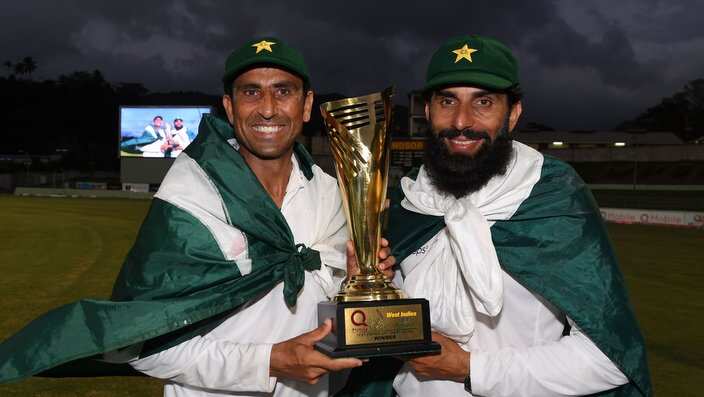 Retiring Pakistan cricket team members Younis Khan (L) and captain Misbah-ul-Haq (R) celebrate with the series trophy  after winning the final test match and the series 2-1 against the West Indies at the Windsor Park Stadium in Roseau, Dominica on May 14,