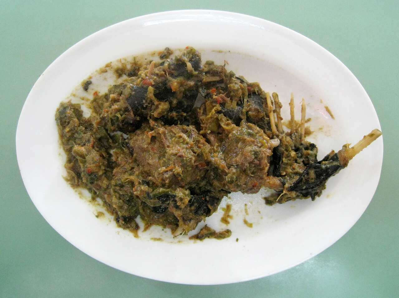 Paniki (Fruit Bat) meat cooked in spicy Rica green chilli pepper. An exotic Manado (Minahasan) dish. Manado, North Sulawesi, Indonesia.
