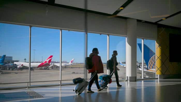 passengers walk to their flights at sydney international airport