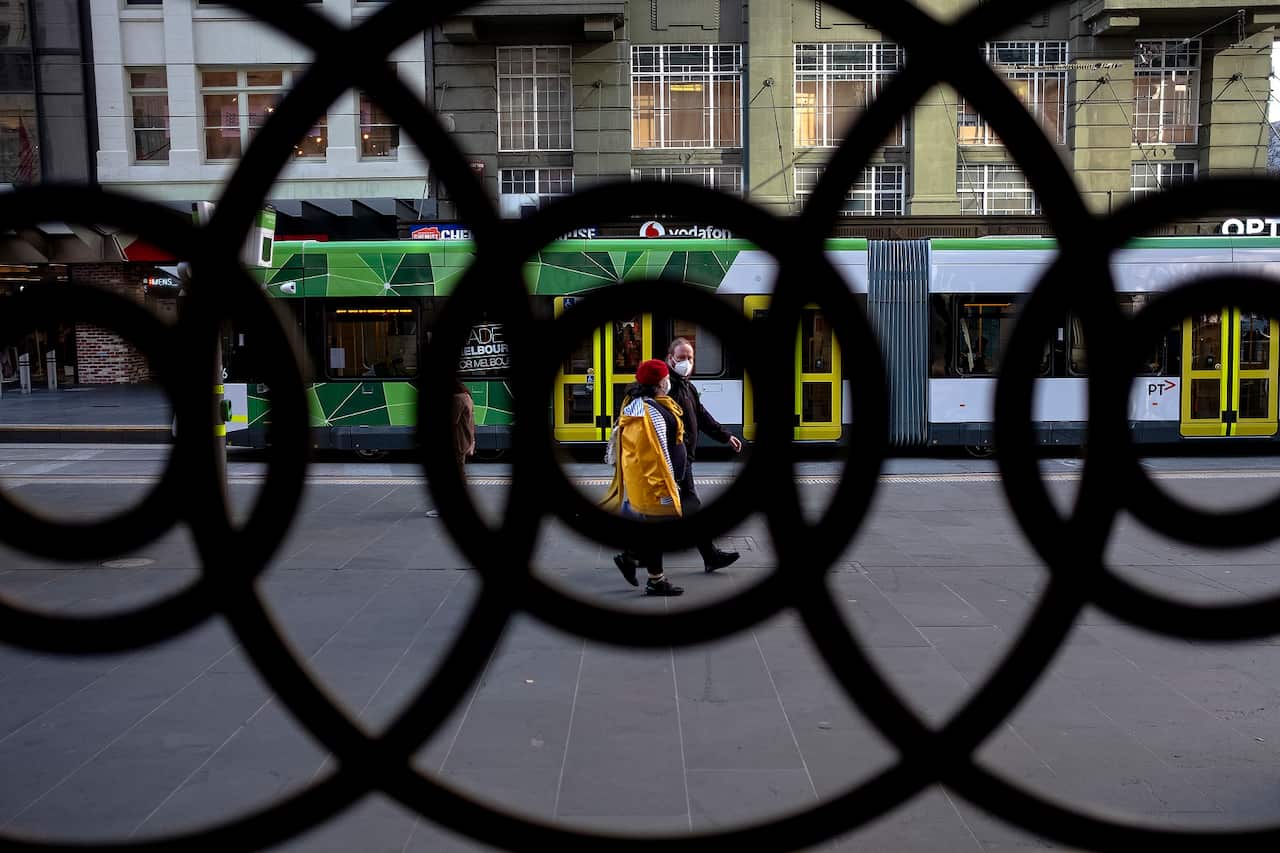 People wearing face masks are seen during a lockdown in Melbourne, Thursday, July 9, 2020. The Melbourne metropolitan area was put in locked down on Thursday in an effort to slow the spread of coronavirus. (AAP Image/Luis Ascui) NO ARCHIVING