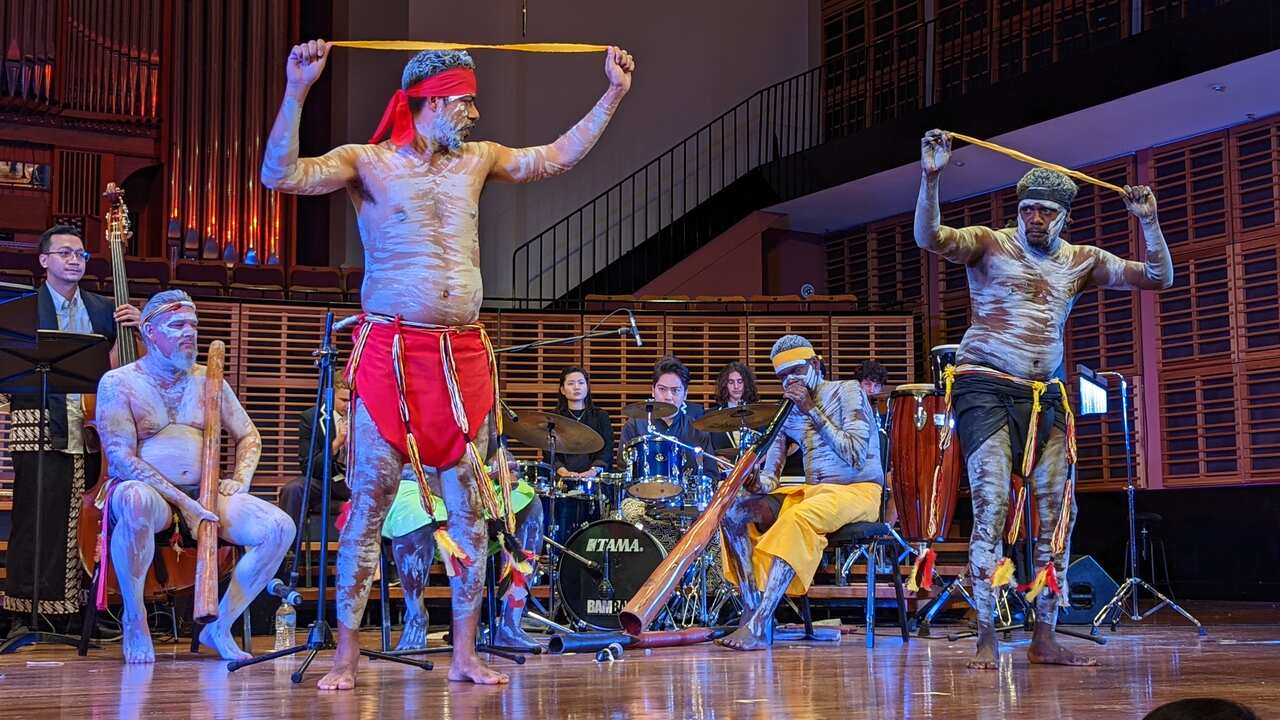 Yolngu man, Arian Pearson (standing, L) performs an Indigenous dance depicting colours brought over by Macassan people.