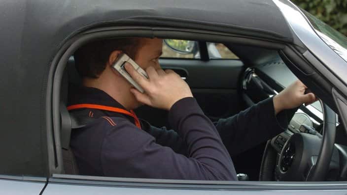 A man using his mobile phone while driving.