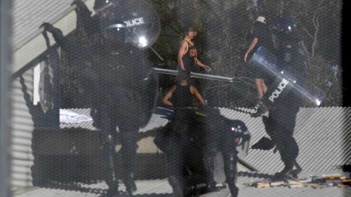 Detainees and Riot police are seen during a riot at the Frank Baxter Juvenile Justice Centre, Kariong, NSW