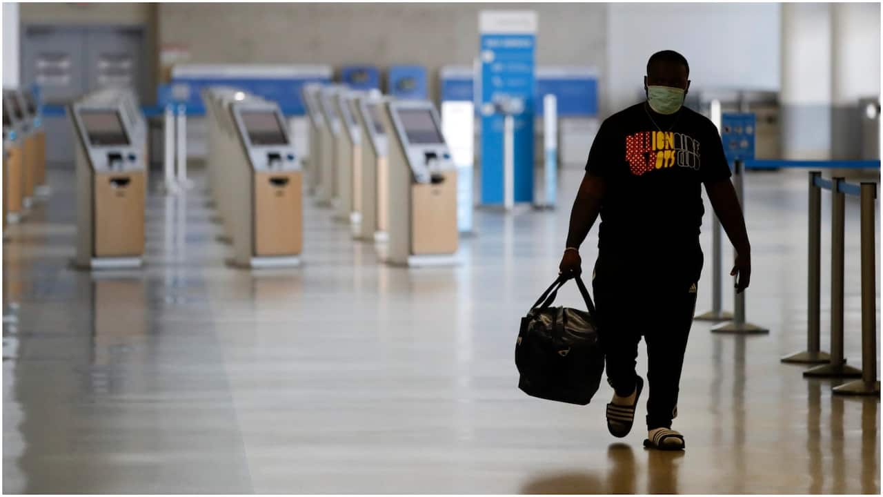 A traveler walks in a mostly empty airport terminal.