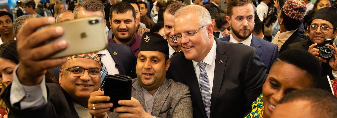 Australian Prime Minister Scott Morrison has a selfie taken with Nepali community members during a visit to the Koondoola Community Centre in Perth SBS