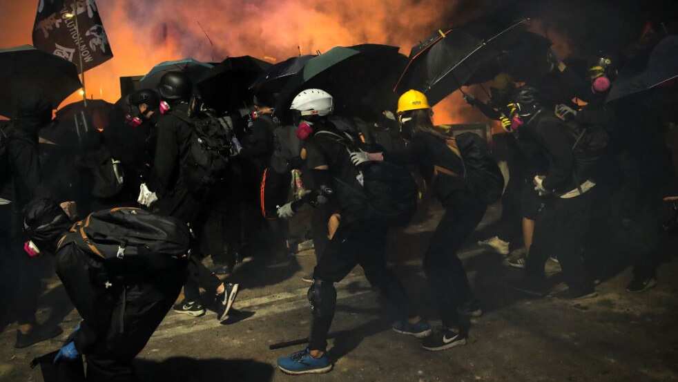 Students use umbrellas as a shield during a clash with police at the Chinese University in Hong Kong, Tuesday, Nov. 12, 2019.