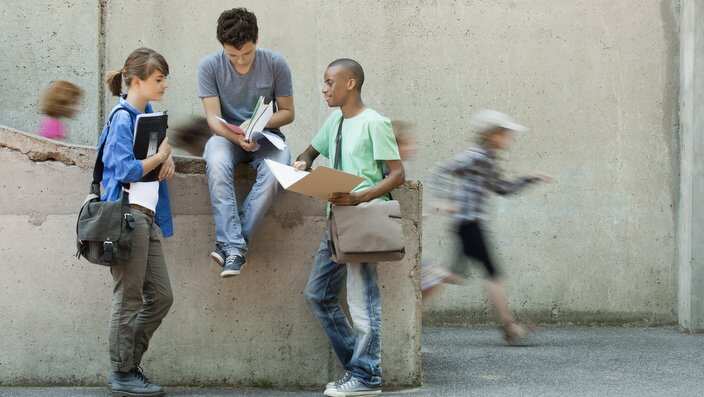 Friends discussing homework together (Getty Images/PhotoAlto/Odilon Dimier)
