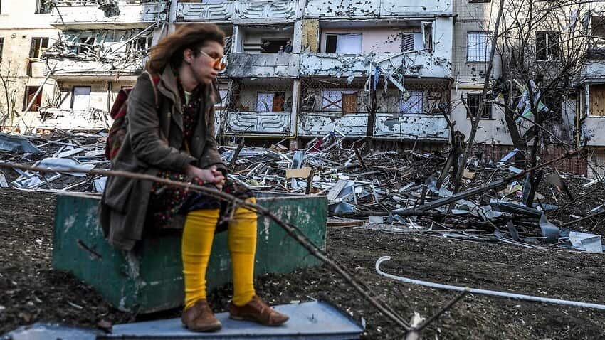 A woman sits next to debris of a building damaged by shelling in Kyiv, Ukraine, 15 March 2022.