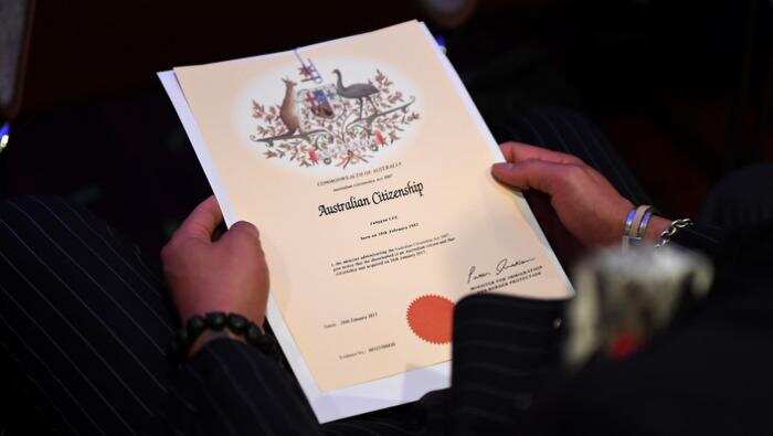 An Australian citizenship recipient holds his certificate during a citizenship ceremony.