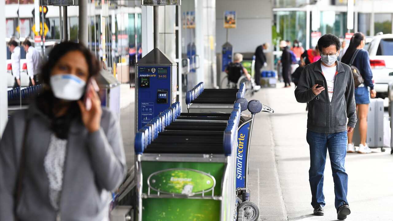 A man with a face mask is seen outside the international departures terminal at Tullamarine Airport, Melbourne, Friday, March 13, 2020. 