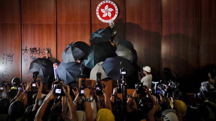 Hong Kong protesters occupying the legislative council, vandalising the wall.