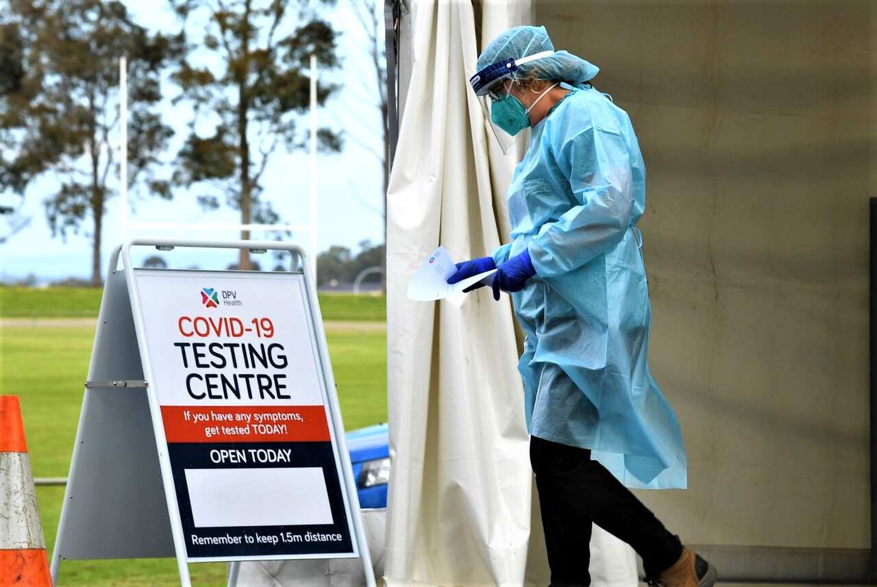 Healthcare workers are seen at a drive through pop up coronavirus testing facility in Clyde, Melbourne. 