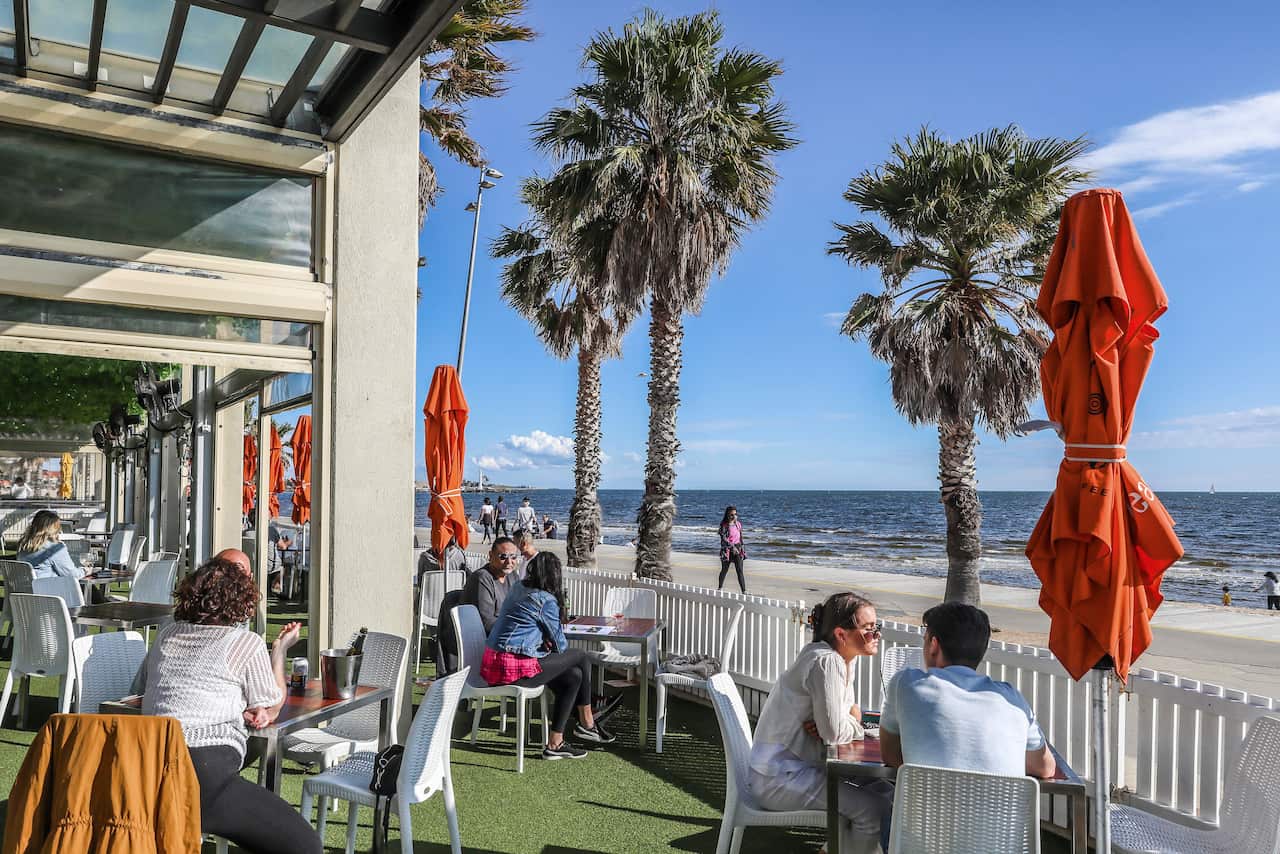 Diners are seen dining at a restaurant and bar looking out towards St Kilda Beach in Melbourne, Australia, Wednesday, Oct 28, 2020