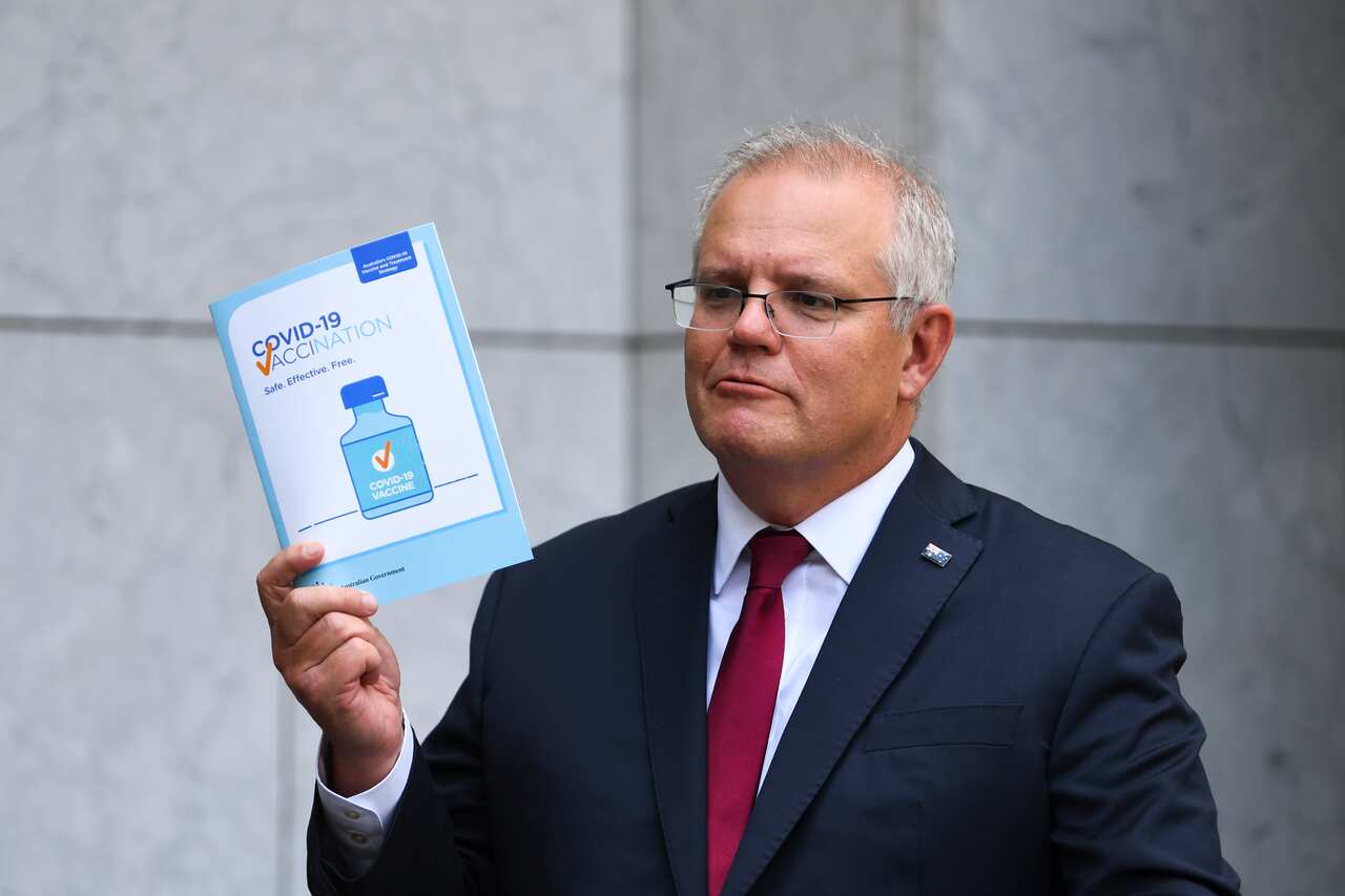 Australian Prime Minister Scott Morrison holds up a COVID19 vaccination leaflet as speaks to the media during a press conference at Parliament House in Canberra, Thursday, February 4, 2021. (AAP Image/Lukas Coch) NO ARCHIVING