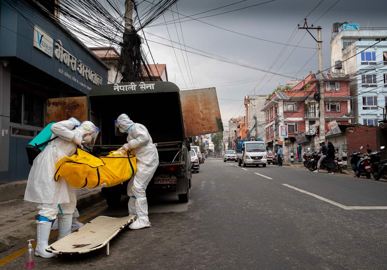 Nepal army personnel unload the body of a person who died of complications from infection with COVID-19, while on their way towards at Pashupati Electric Crematorium in Kathmandu, Nepal, 05 May 2021.  