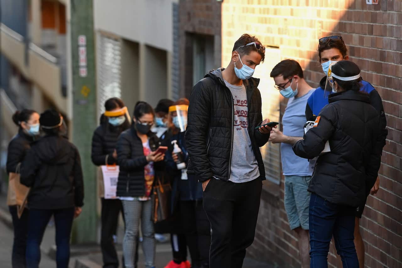 People wearing face masks line up for their COVID-19 vaccination at the NSW Health Walk-in AstraZeneca vaccination clinic in Glebe, Sydney, Sat, Aug 7, 2021.