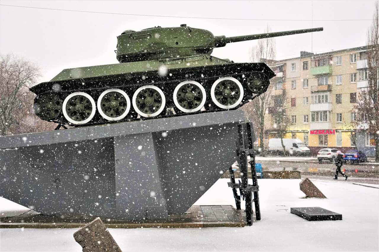 A person walks during a snowfall by a WWII memorial, in Sievierodonetsk, the Luhansk region, eastern Ukraine, Saturday, Feb. 12, 2022. 