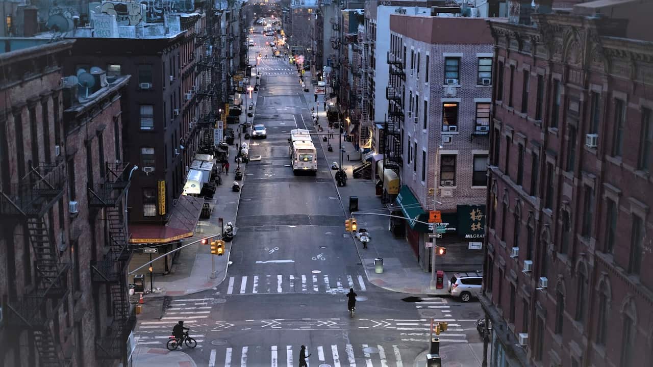 Bicyclists and a pedestrian pass through a quiet Manhattan street, Thursday, March 26, 2020, during the coronavirus pandemic in New York.
