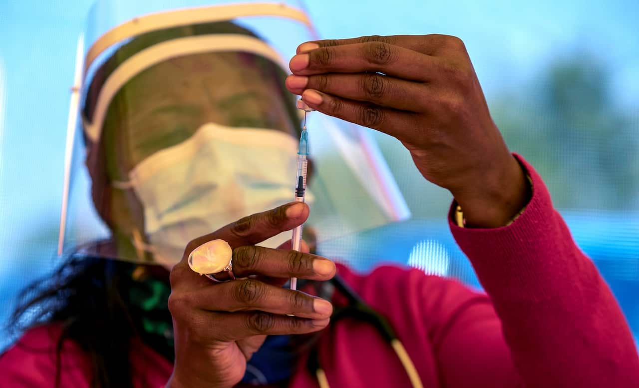 A health worker prepares a dose of the Pfizer coronavirus vaccine at the newly-opened mass vaccination program for the elderly at a drive-thru vaccination center outside Johannesburg, South Africa, 