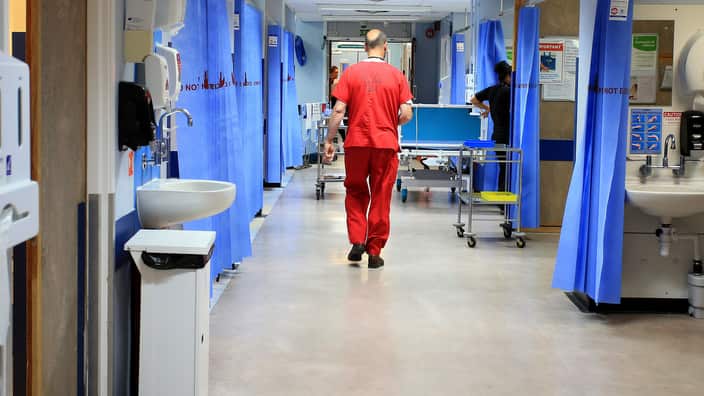 New parents watching babies in hospital nursery