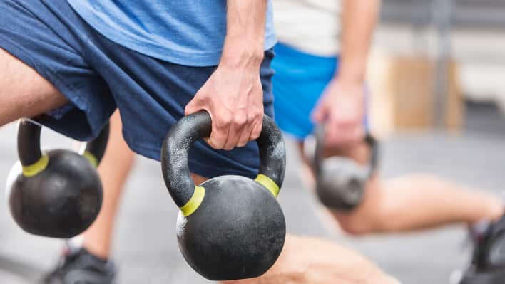 Men lifting kettleballs in a gym