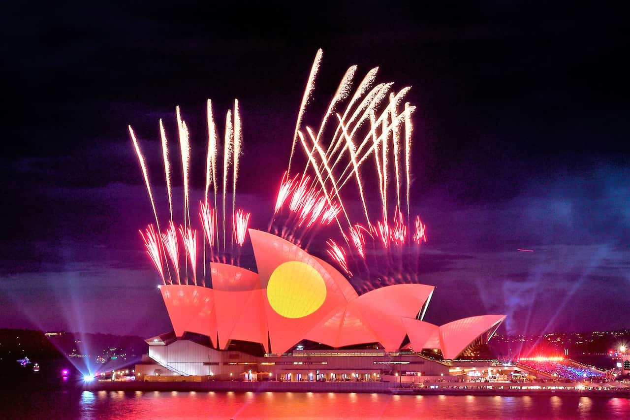 Fireworks are seen as the Aboriginal flag is projected onto the sails of the Sydney Opera House during Australia Day celebrations. 