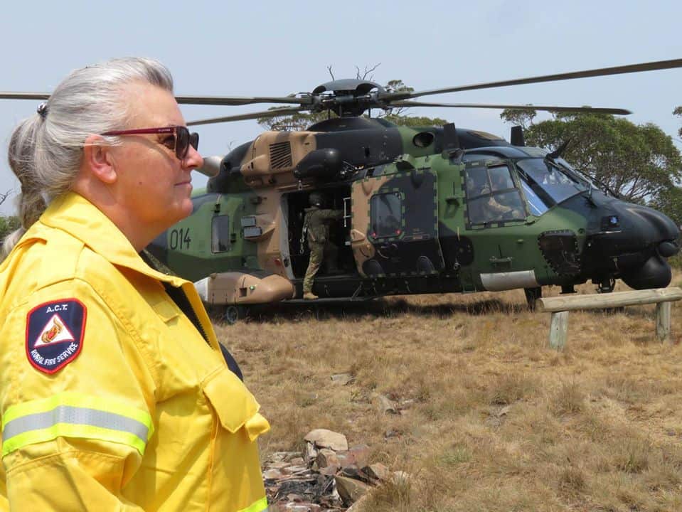 Firefighter standing by a military aircraft