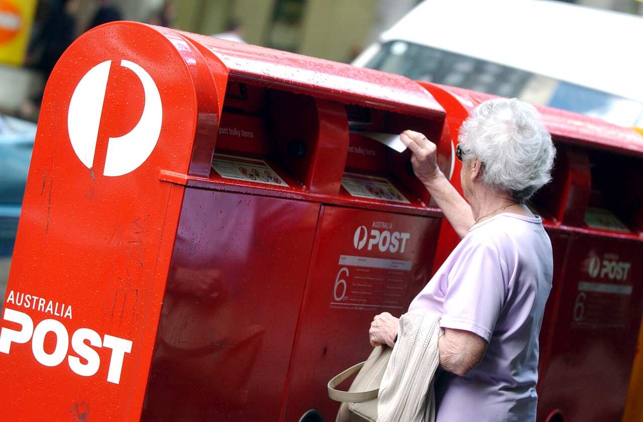 A woman posts a letter in one of the Australian post boxes in the city of Sydney. (AAP Image/Dean Lewins). NO ARCHIVING.