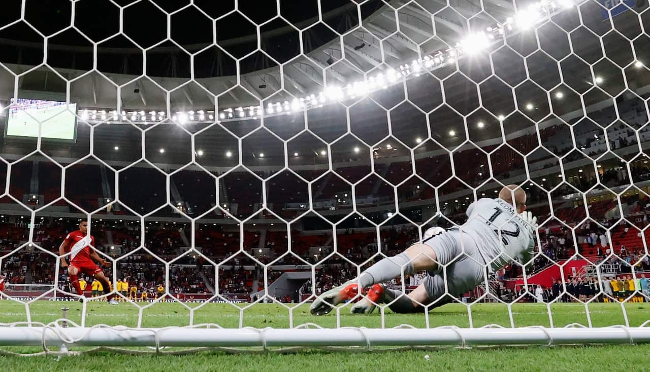 Australia goalkeeper Andrew Redmayne saves a penalty from Peru's Alex Valera (AAP)