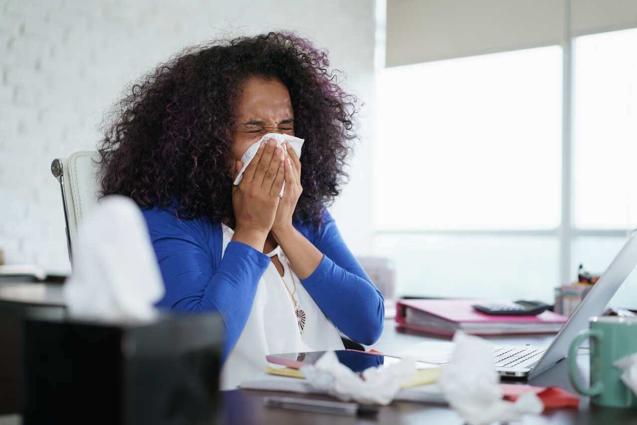Woman Working from Home And Sneezing For Cold