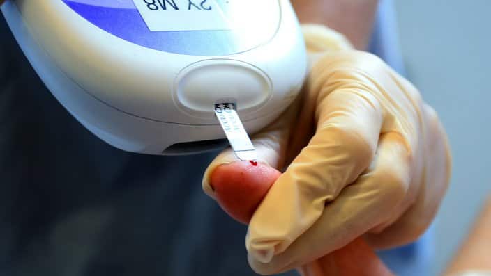 A nurse giving a patient a diabetes test