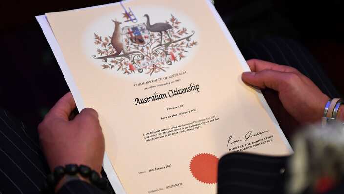An Australian citizenship recipient holds his certificate during a citizenship ceremony on Australia Day in Brisbane, Thursday, Jan. 26, 2017. (AAP Image/Dan Peled) NO ARCHIVING