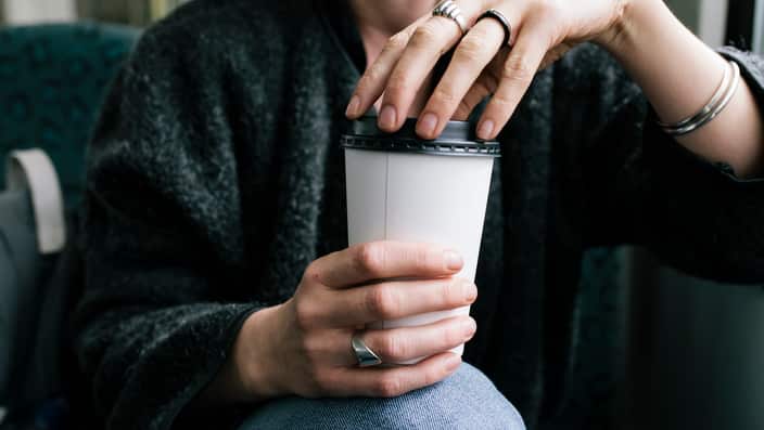 A Woman Holding A Takeout Coffee