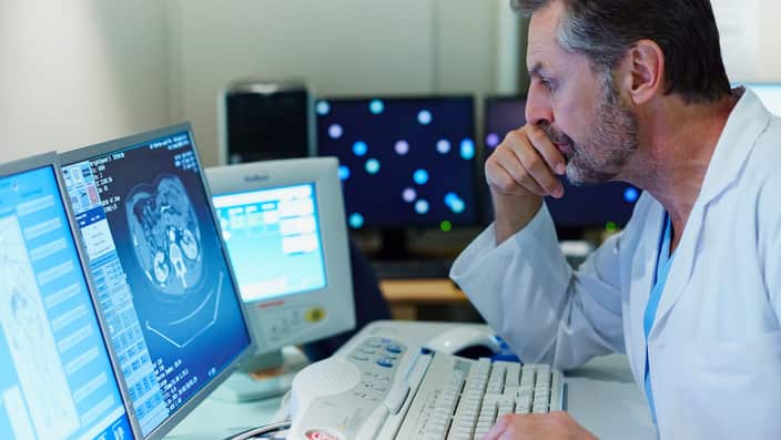 Doctor examining CT scan in control room