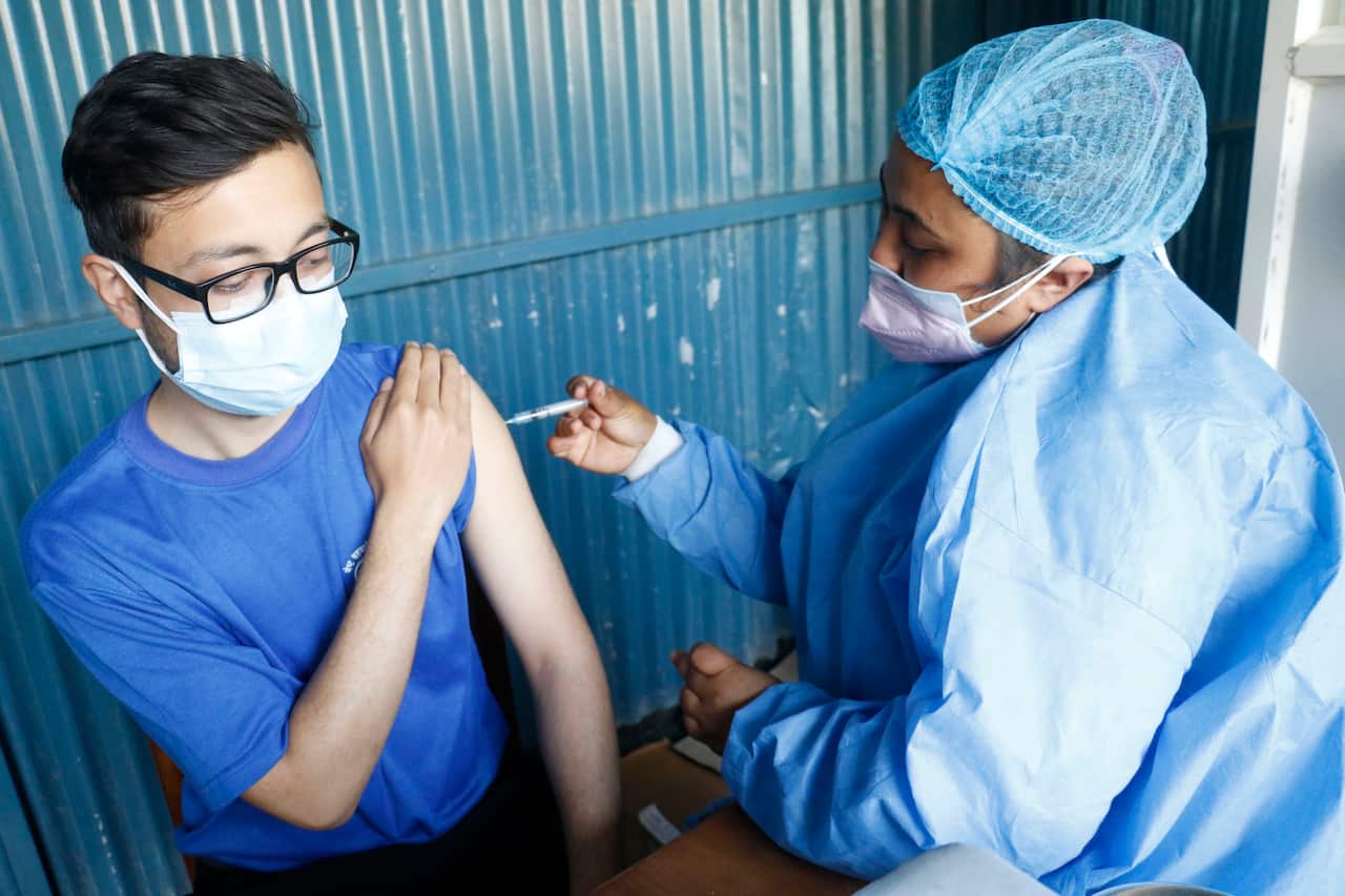Nepali health workers receiving COVID-19 vaccine at a Kathmandu hospital.