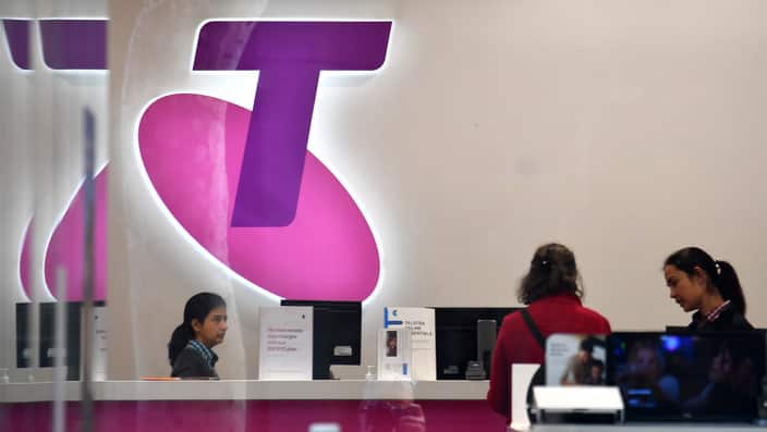 Customers and assistants are seen in a Telstra store in Sydney