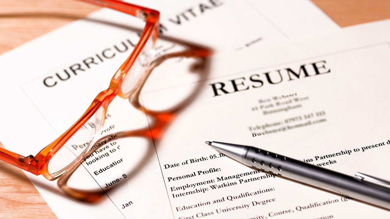 CV and resume with glasses and pen.