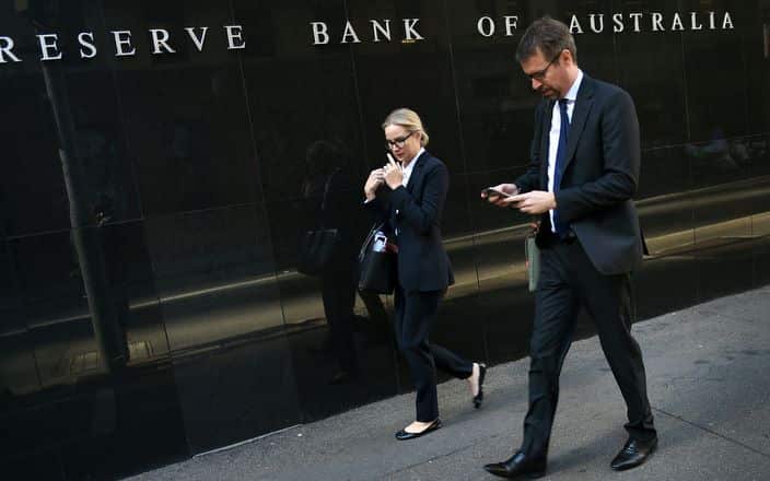 People walk past the Reserve Bank of Australia building 